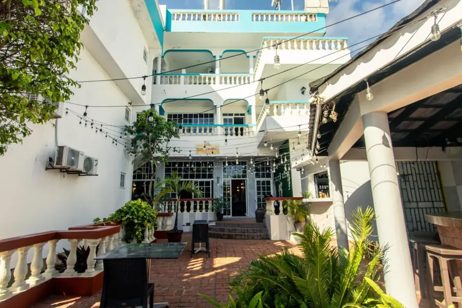 The courtyard of The Match Resort, with the white building and its balconies and lights over the terrace